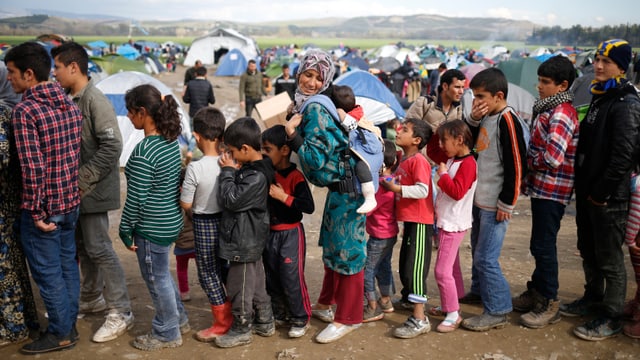 Menschen, darunter viele Kinder, stehen Schlange vor der Essensausgabe