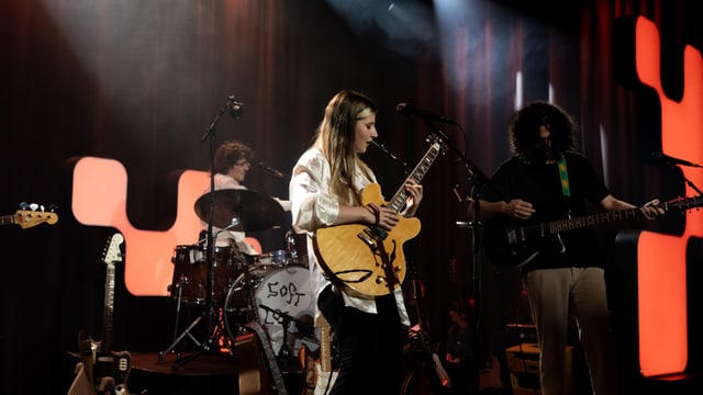 Band spielt auf einer Bühne mit rotem Licht