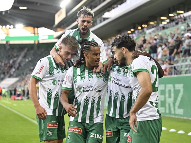 Fussballspieler feiern ein Tor im Stadion.