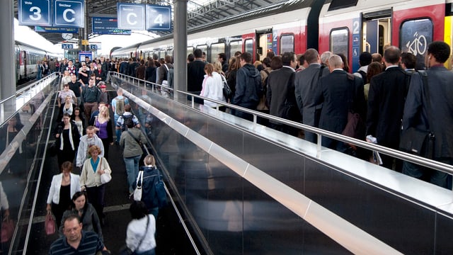 Menschen an einem Bahnhof.