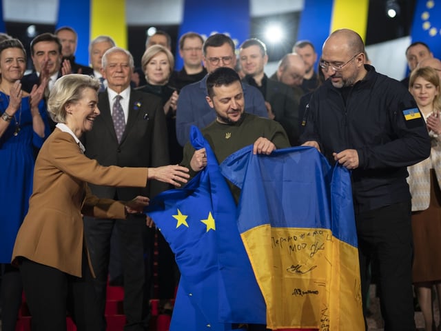 Von der Leyen, Selenski und Shmyhal mit zwei Flaggen.