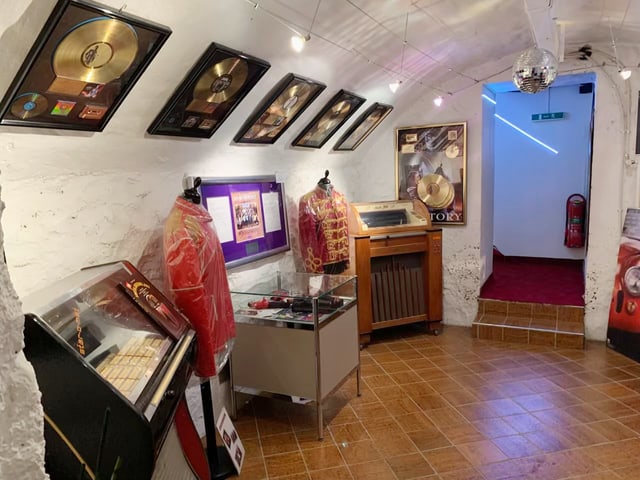 Museumsausstellung mit goldenen Schallplatten an der Wand.