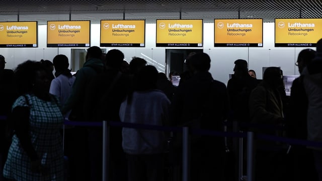 Flughafen-Schalter der Lufthansa, davor anstehende Menschen.