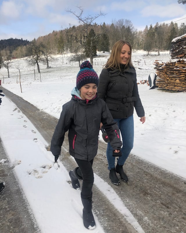 Anna und Sina laufen über einen Feldweg.