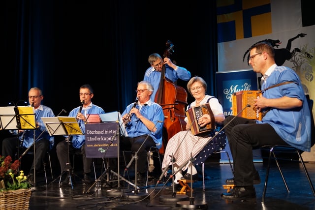 Musiker:innen spielen auf der Bühne.