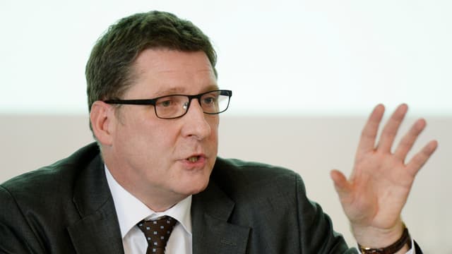 Norbert Klapper gestikuliert und spricht an der Pressekonferenz.