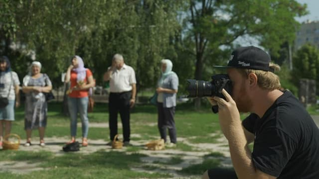 Fotograf und Menschen mit Körben