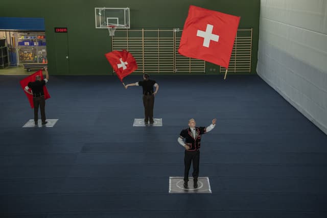 Eine Gruppe von Fahnenschwingern in einer Turnhalle.