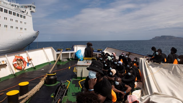 Geflüchtete auf einem Boot auf offener See.