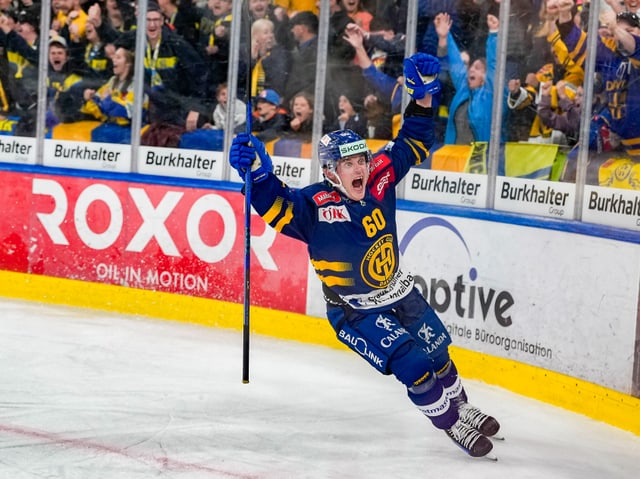 Eishockeyspieler beim Torjubel vor jubelnden Fans.