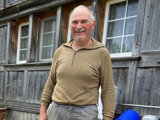 Ein Mann vor einem Bauernhaus