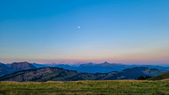 View from the Hochalp over the landscape under a cloudless sky.