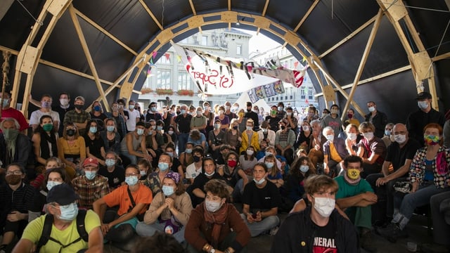 Climate activists listen to speeches by MPs in a tent on the Bundesplatz. 