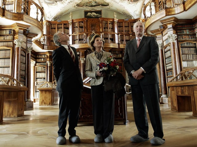 Drei Personen in der Stiftsbibliothek stehend.