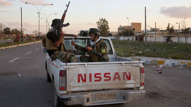 Schiitische Milizen auf einem Nissan-Truck patrouillieren durch die leeren Strassen von Tikrit.