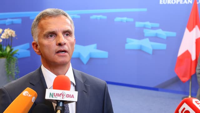 Burkhalter spricht in Mikrofone von TV-Stationen, hinter ihm eine Projektion des EU-Logos und eine Schweizer Fahne.