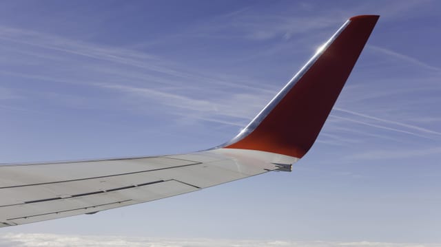 Ein Winglet eines Flugzeugs über den Wolken.