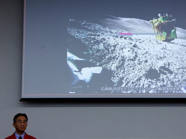 Der Projektmanager der Raumfahrtbehörde Jaxa mit einem Mondbild. 