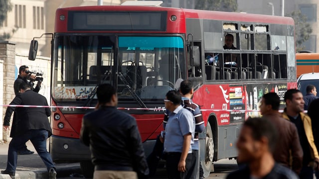 Menschen an einem demolierten Bus