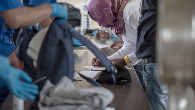 Gepäck von Flüchtlingen wird am Grenzübergang in Chiasso durchsucht. 