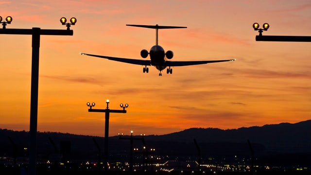 Ein Flugzeug im Landeanflug im Abendrot.