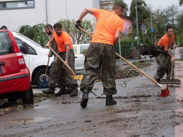 Einsatzkräfte reinigen Strasse von Schutt