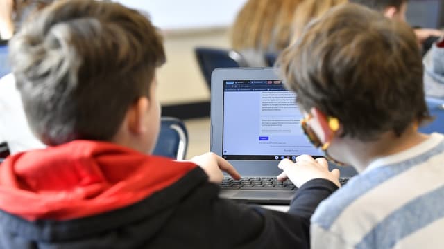 Zwei Schüler vor einem Laptop.