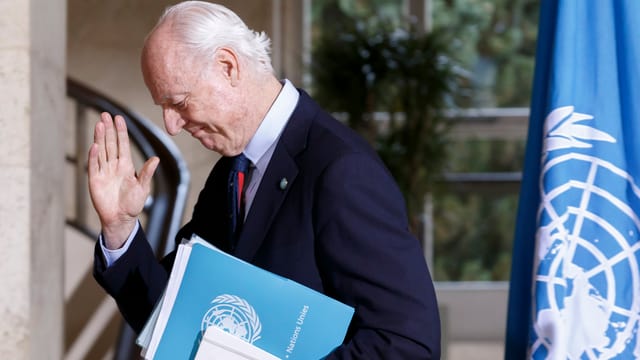 Staffan de Mistura, der UNO-Gesandte für Syrien steht neben der UNO-Flagge. 