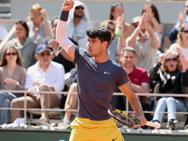 Tennisspieler jubelt auf dem Platz, während das Publikum applaudiert.