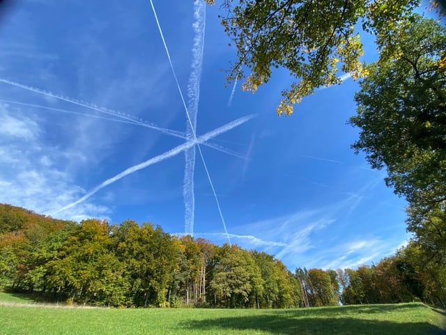 Kondensstreifen bilden vor blauem Himmel eine Art Sternenmuster