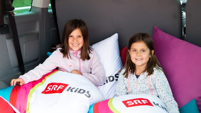 Zwei Mädchen relaxen im SRF Kids Bus