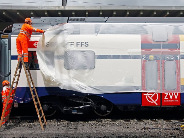 Arbeiter enthüllen die neue S-Bahn für Zürich. (keystone)