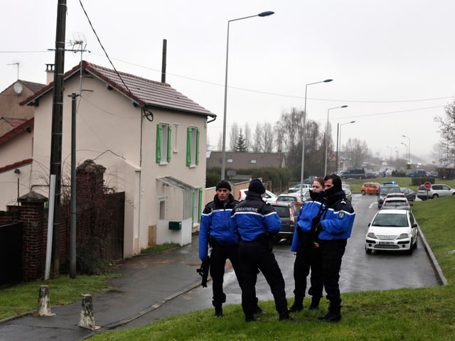 Polizisten bewachen eine Zufahrtsstrasse