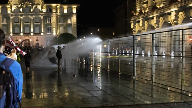 Die Polizei setzt Wasserwerfer gegen Demonstranten vor dem Bundeshaus ein.