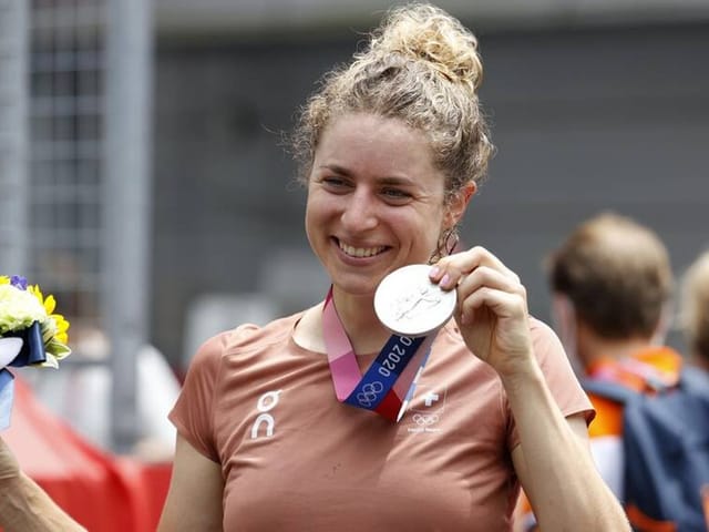 Frau mit Silbermedaille bei Sportveranstaltung.