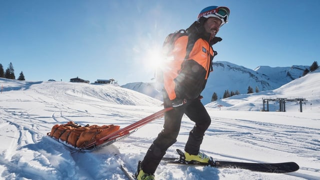 Ein Skifahrer mit einem Rettungsschlitten.