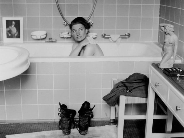 Frau in Badewanne, Stiefel davor, Badezimmer.