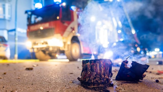 Feuerwehrauto steht vor einem brennenden Gebäude.