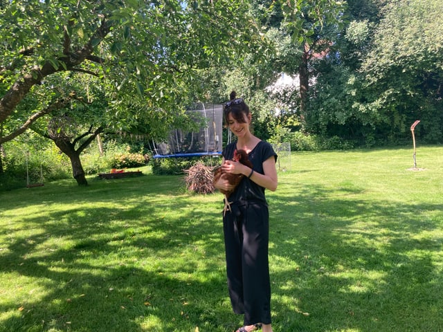 Reporterin Sharon Zucker hält ein Huhn.