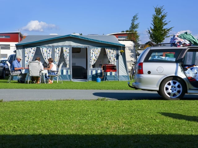 Eine Gruppe älterer Leute sitzt 2008 vor ihrem Wohnwagen auf dem Campingplatz "Seeland" in Sempach.