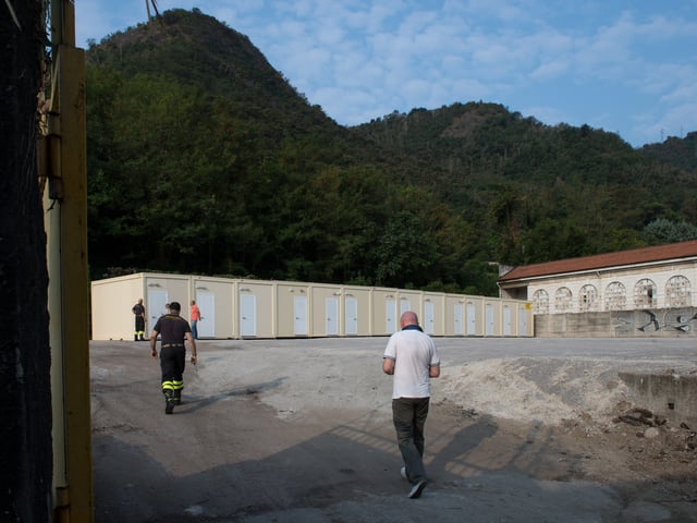 Blick auf einen leeren Hof mit Containern im Hintergrund