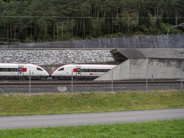 Ein Personenzug fährt in ein Tunnelportal ein.