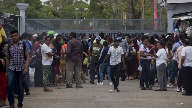 People stand in front of a prison door