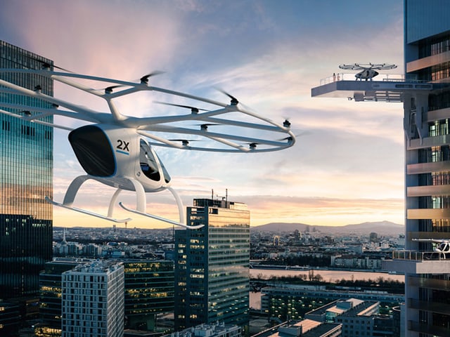 Zwei Volocopter zwischen Hochhäusern.