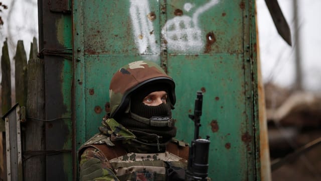 Soldat mit Gesichtsmaske und Gewehr.