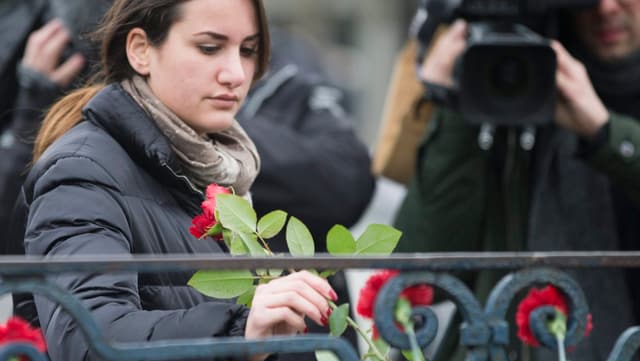 Eine Frau legt am Ort des Bombenattentats in Istanbul Rosen nieder.