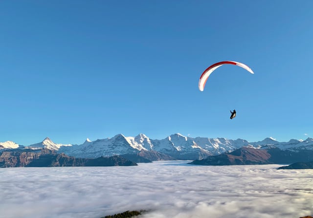 Ein Gleitschirm über dem Hochnebel.