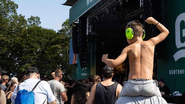 Junger Fan am Gurtenfestival auf den Armen seines Vaters