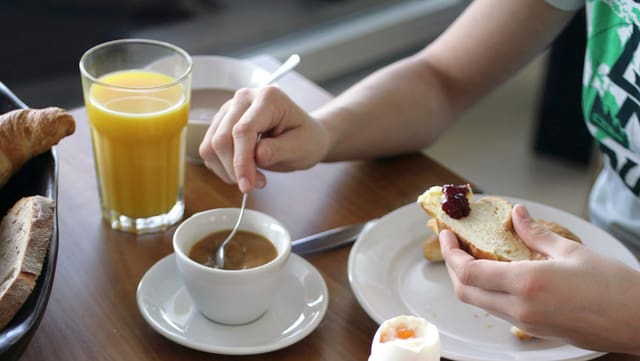 Kaffe, Orangensaft, Ei und Brot mit Marmelade.