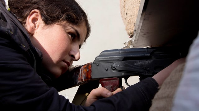 Frau mit Gewehr in der Hand.